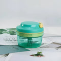 Green manual kitchen grinder with stainless steel blade for baby food and garlic.