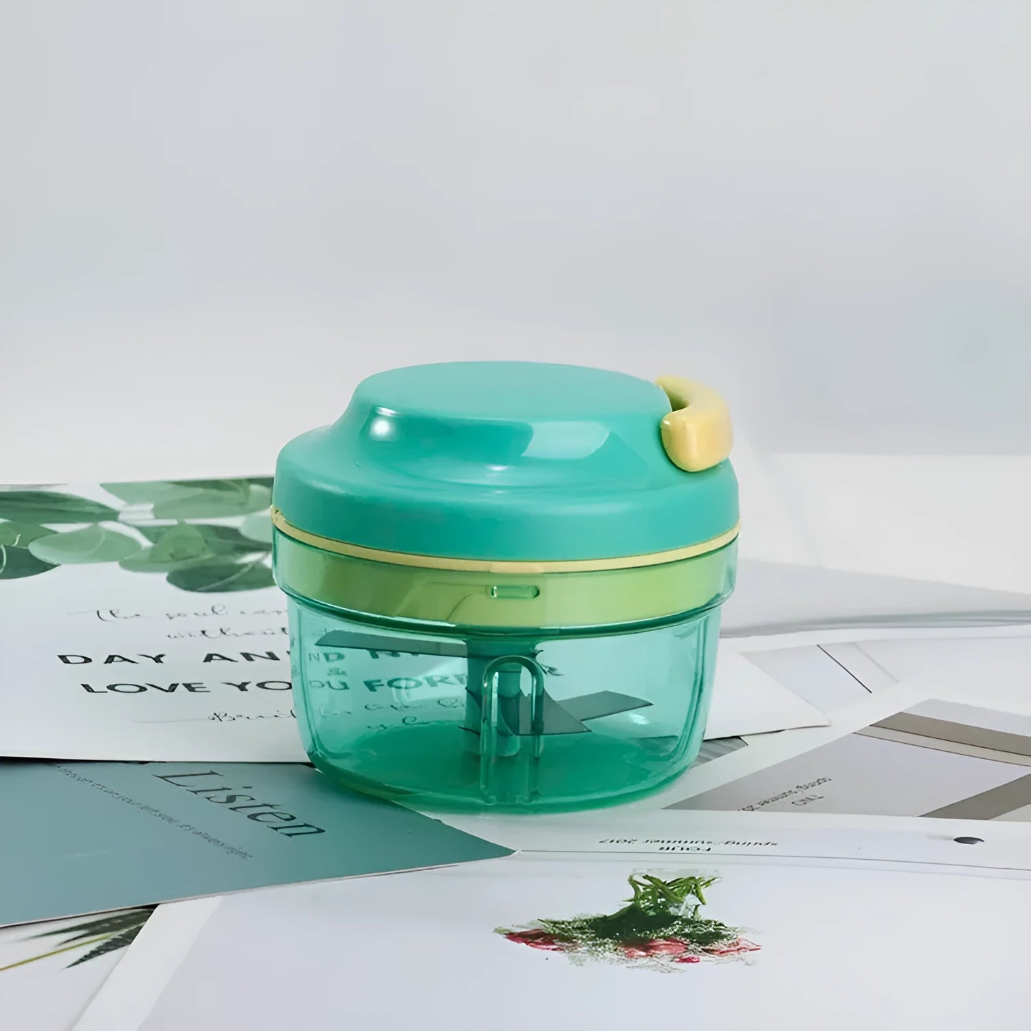 Green manual kitchen grinder with stainless steel blade for baby food and garlic.