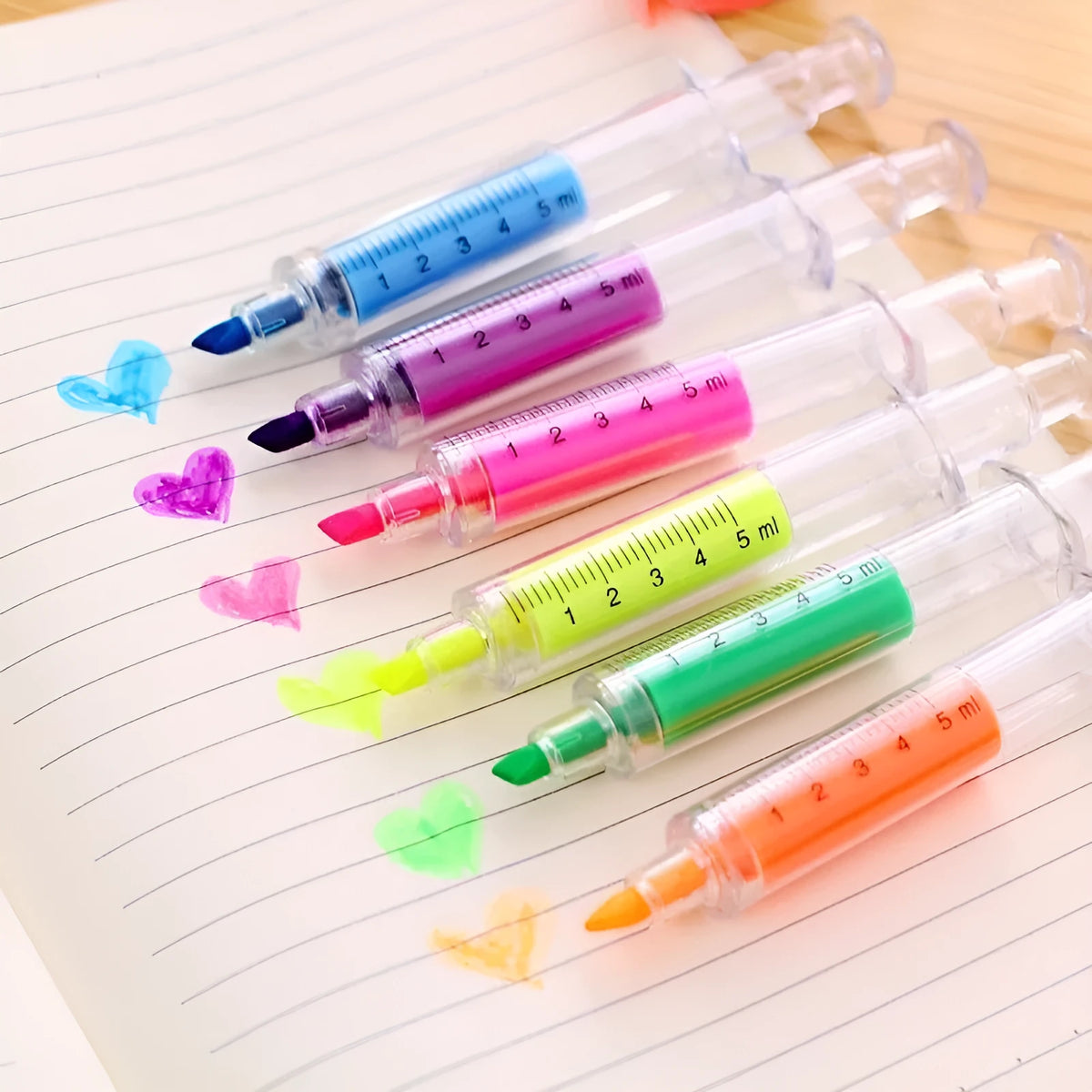 Six syringe-shaped fluorescent highlighter pens in red, orange, blue, yellow, green, and purple with oblique brush tips