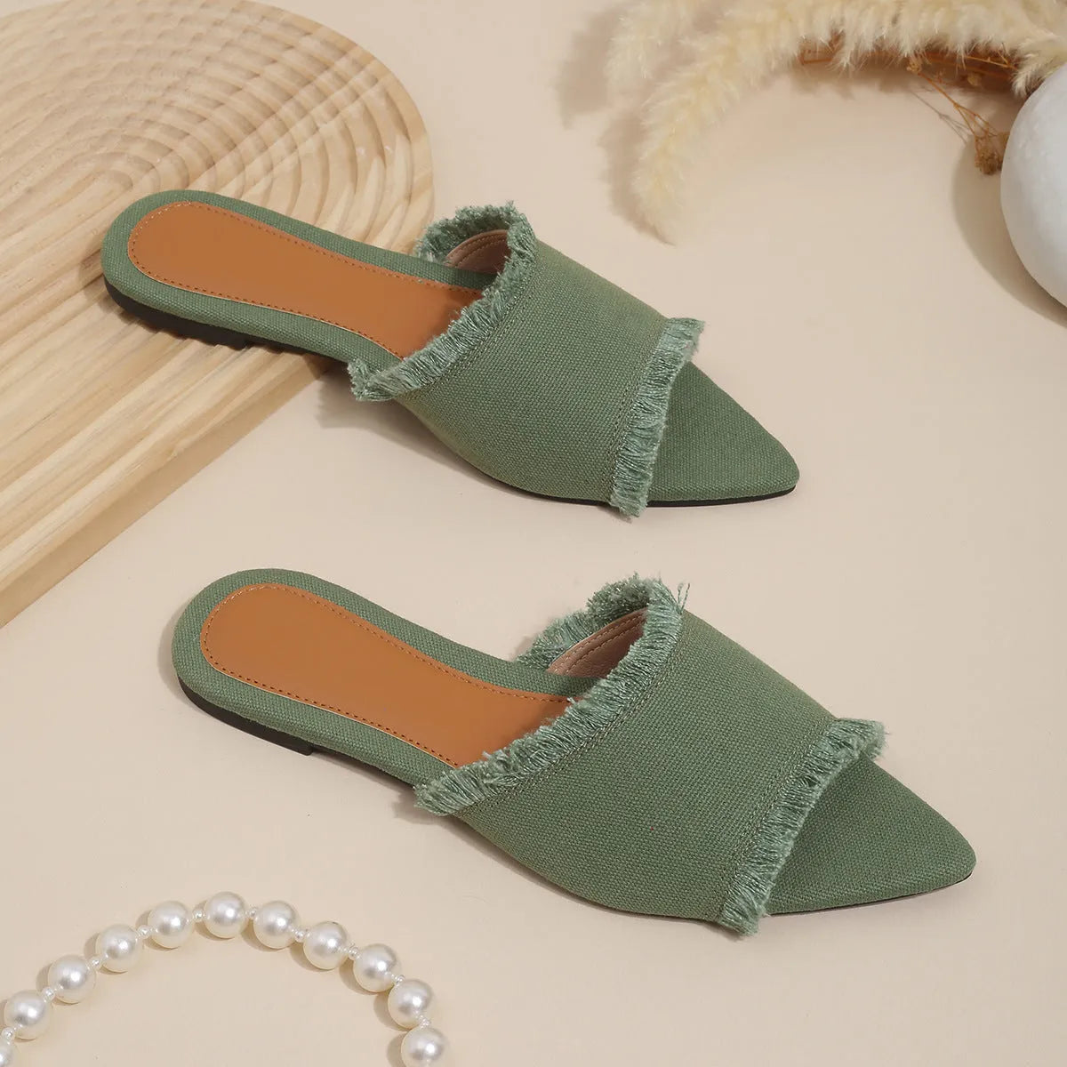 Women's denim flat slipper with tassel detail in apricot colour on a neutral background.