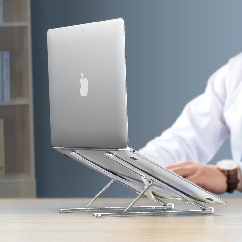 Deep grey foldable aluminium laptop stand holding a silver laptop at an angle.