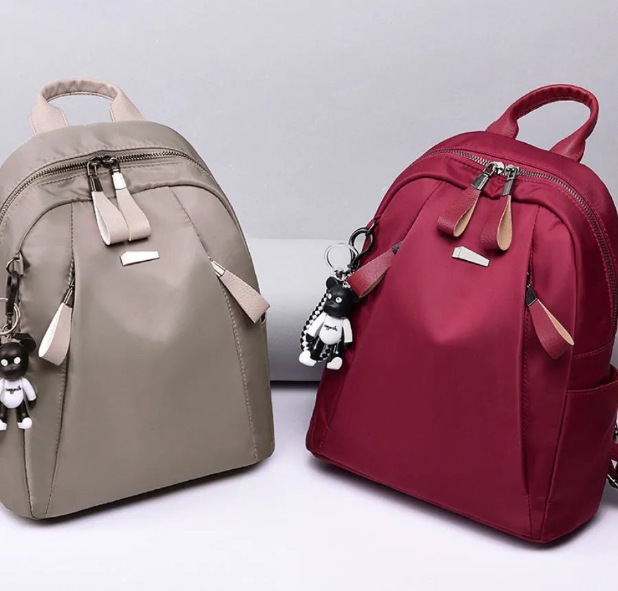 Medium-sized Oxford cloth rucksack in grey with double shoulder straps and a top handle.