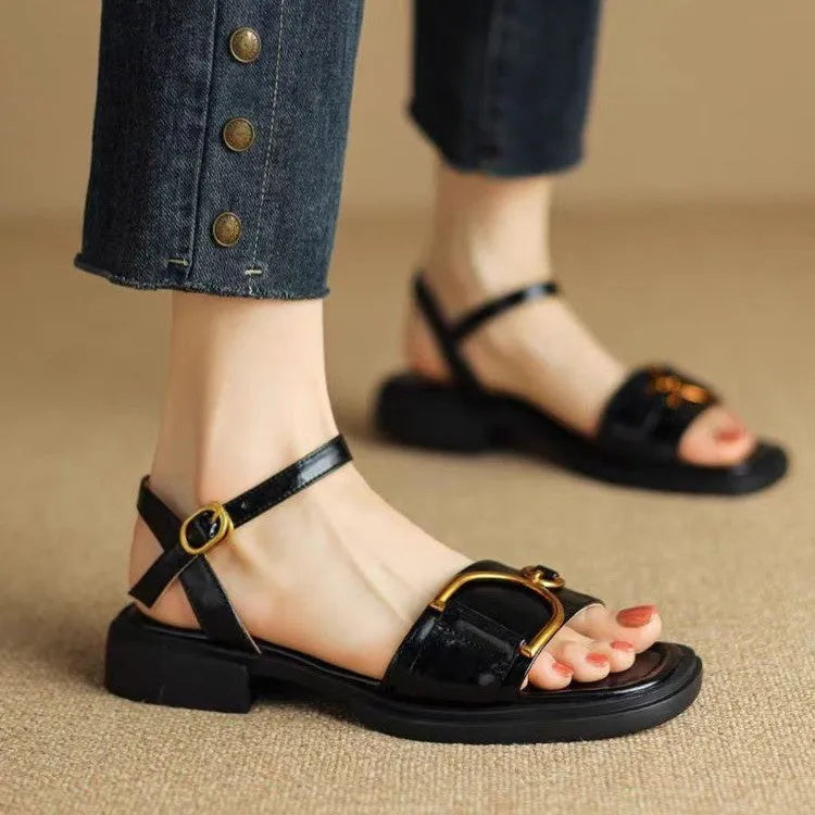Women's black leather thick-soled sandals with a round toe and buckle closure on a white background