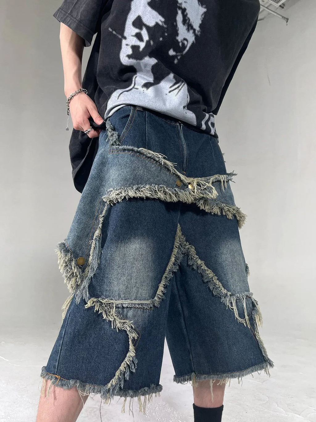 Blue cotton men's denim shorts with frayed hem and embroidered star, loose fit style.