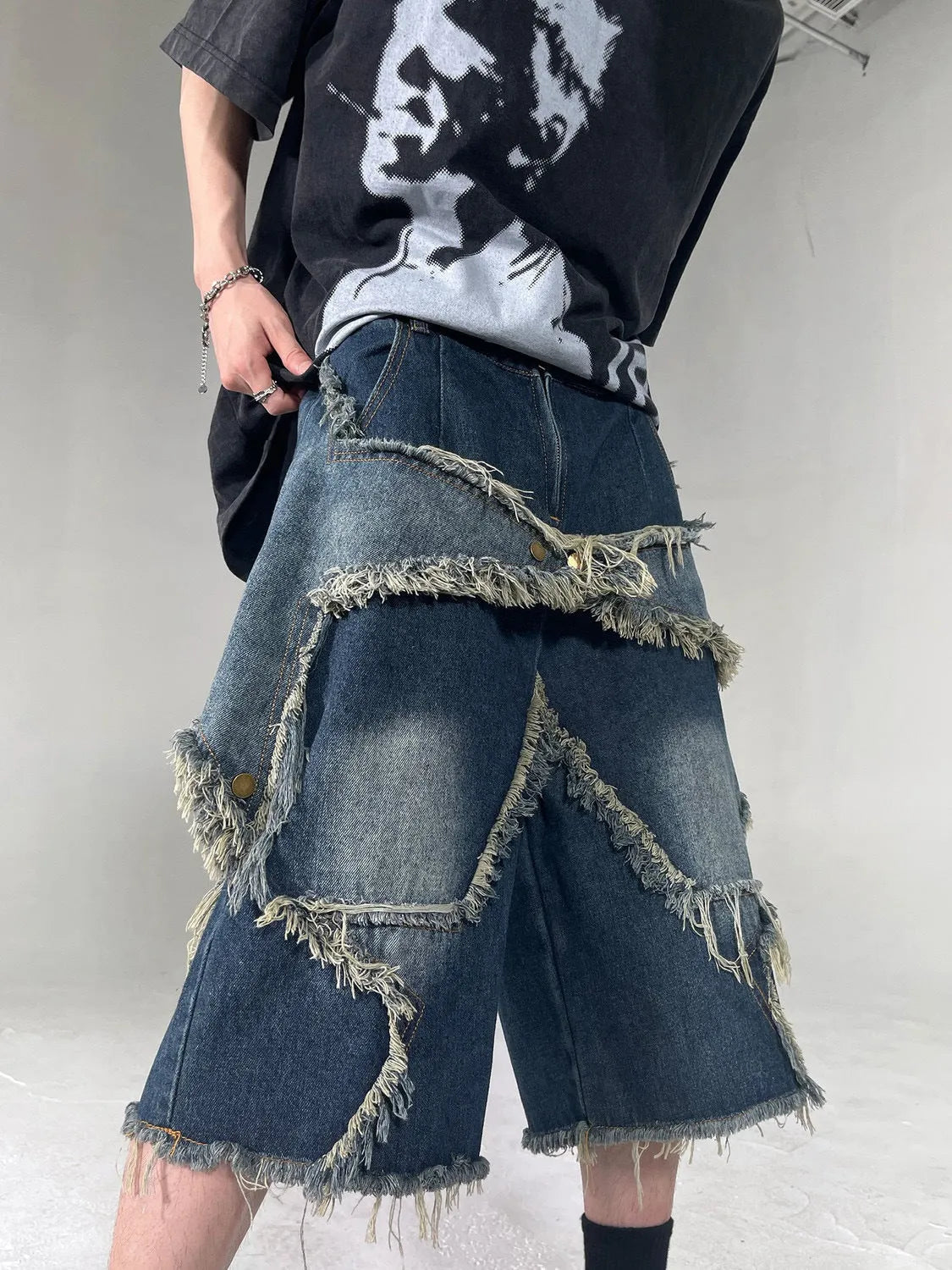 Blue cotton men's denim shorts with frayed hem and embroidered star, loose fit style.