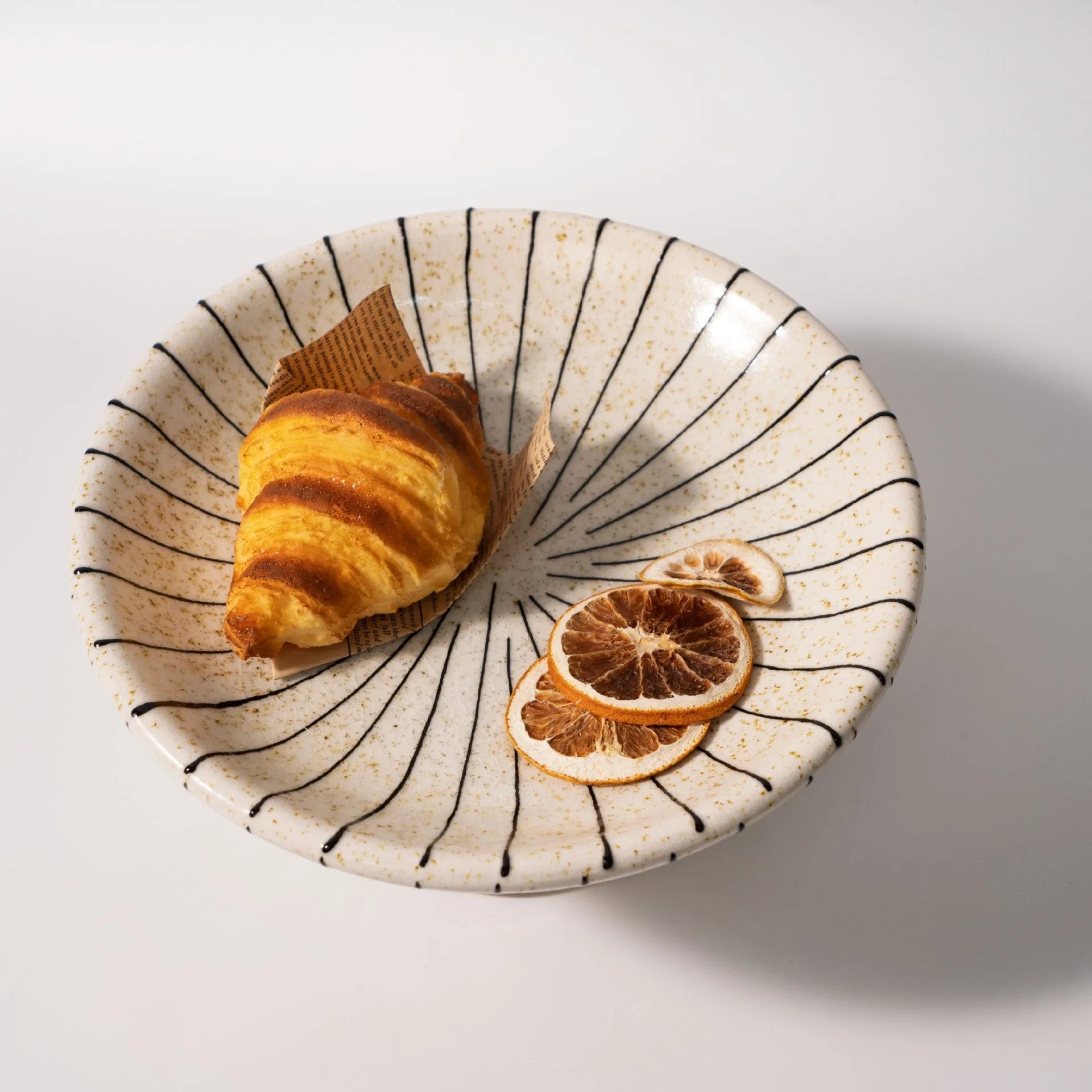 Black and white striped synthetic resin fruit plate on table