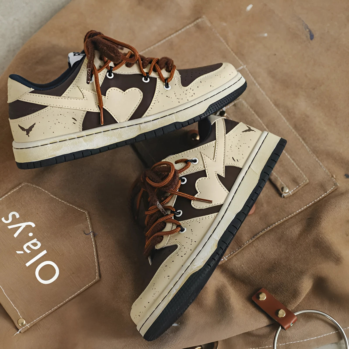 Brown low-top unisex casual sneakers with leather stitching, rubber sole, and front lace-up