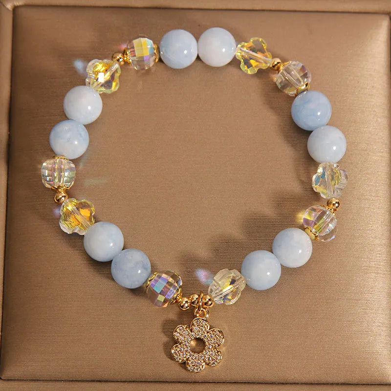Women's aquamarine crystal bracelet with four-leaf clover charm and pearl accent on a chain