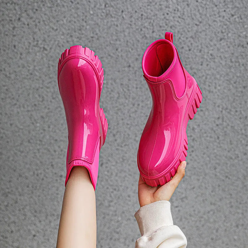 Creamy-white low tube PVC rain boot with non-slip sole on a wet surface.