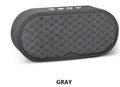 Portable grey Bluetooth speaker with HD microphone on a table
