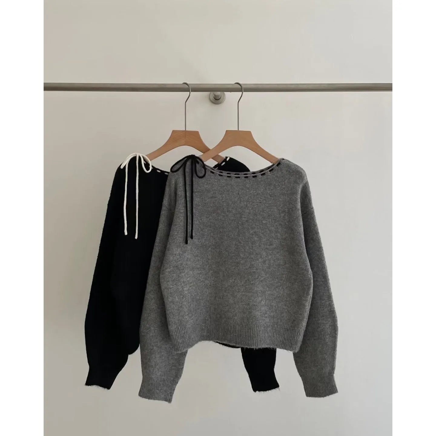 Grey loose-fitting women's pullover sweater made from regenerated cellulose knitwear on a hanger.