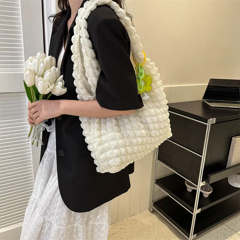 Soft pleated square bubble bag in beige with a removable pendant and single shoulder strap.