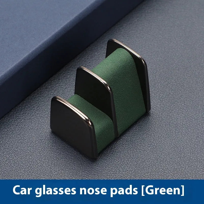 Zinc alloy and leather car dashboard clip for holding sunglasses, shown in green.