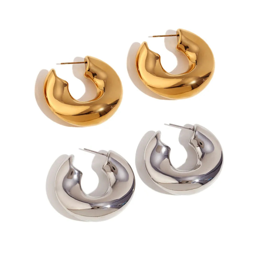 Gold and silver hollow irregular stainless steel earrings with geometric line design on white background
