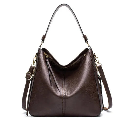 Hobos zipper bucket bag in black with adjustable shoulder strap on a woman's shoulder