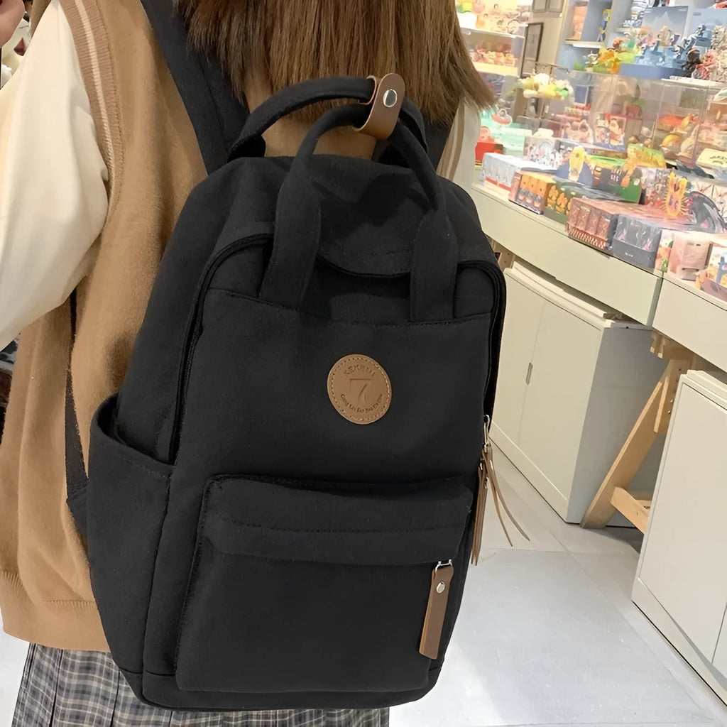Black retro style Oxford cloth unisex backpack with curved shoulder straps.