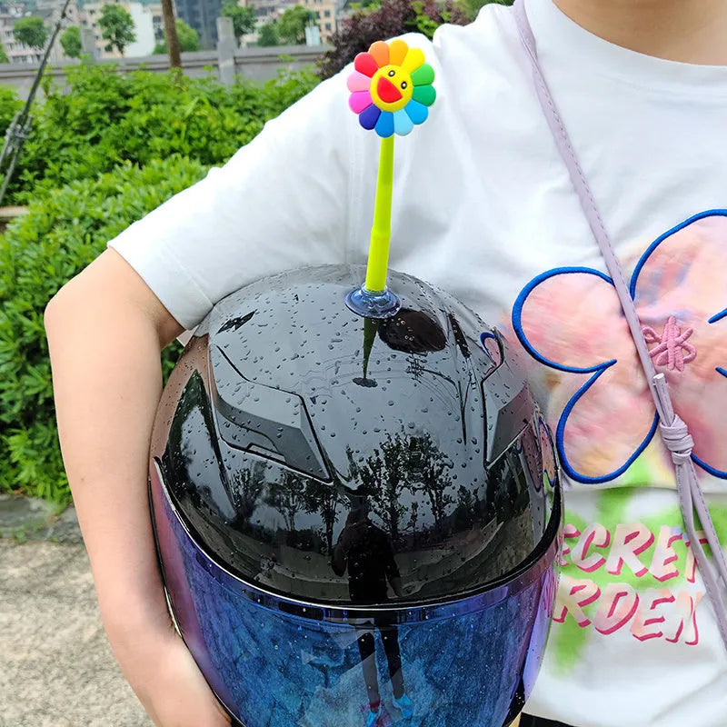 Yellow silicone sunflower decoration with a suction cup base for attaching to a helmet.