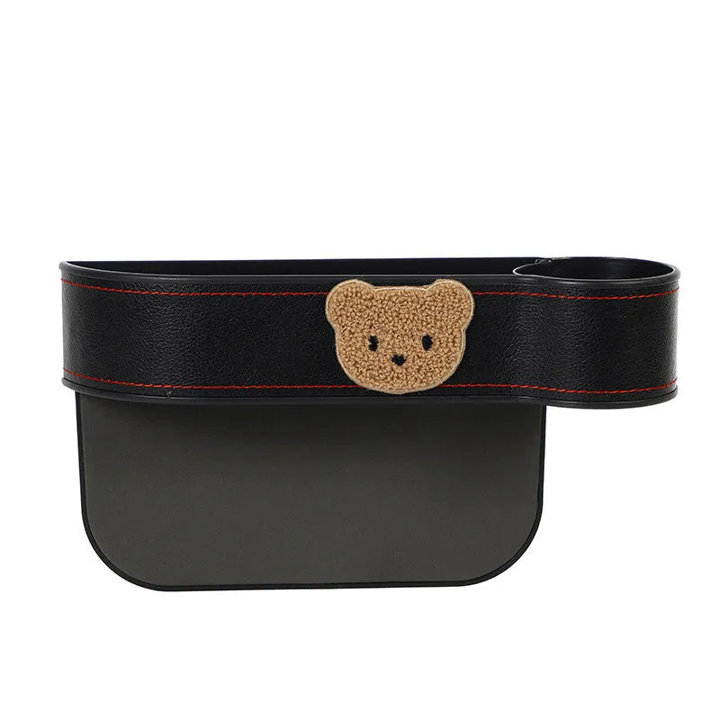 Leather car seat gap storage box with cartoon bear design, shown fitted next to a car seat.