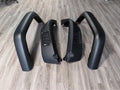 Set of 4 black plastic car wheel brow trims for universal automotive use on a white background