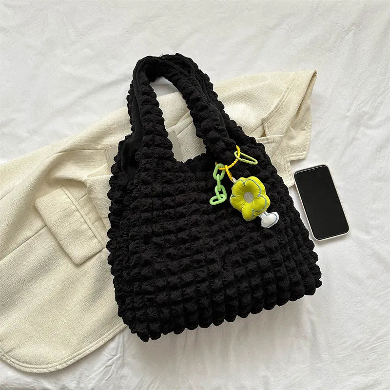 Soft pleated square bubble bag in beige with a removable pendant and single shoulder strap.
