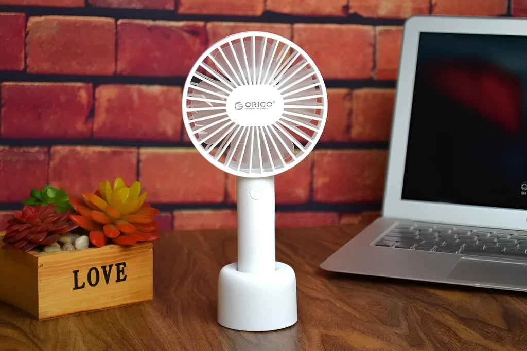 White ORICO FH1 USB rechargeable desk fan with fine-line texture on a desk, showing compact size.