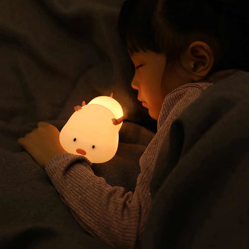 Pink silicone pig-shaped night light with touch control on bedside table