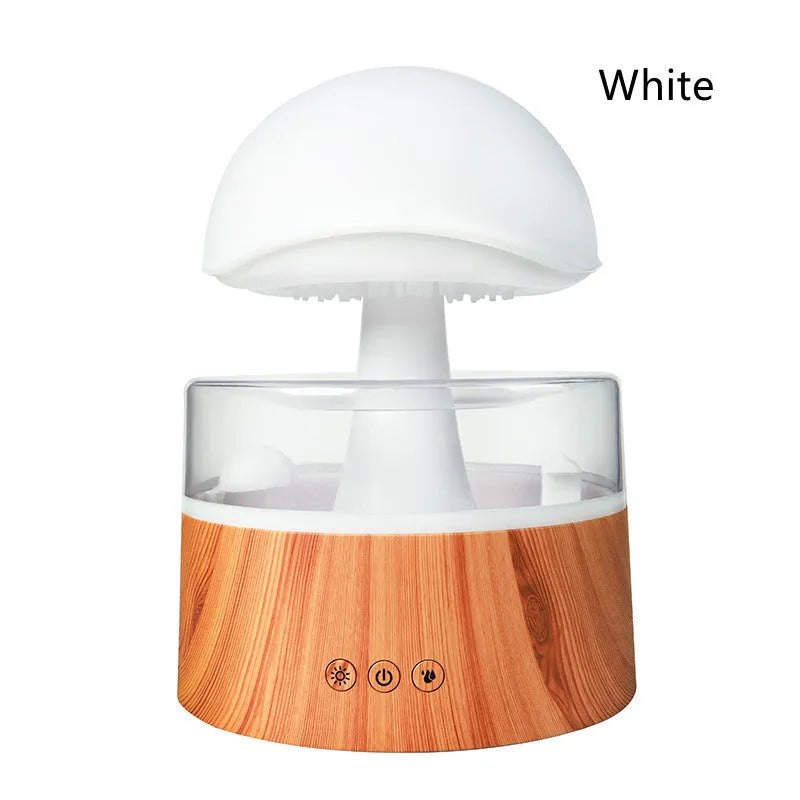 White cloud-shaped humidifier with falling raindrop mist and multi-colour night light on wooden table