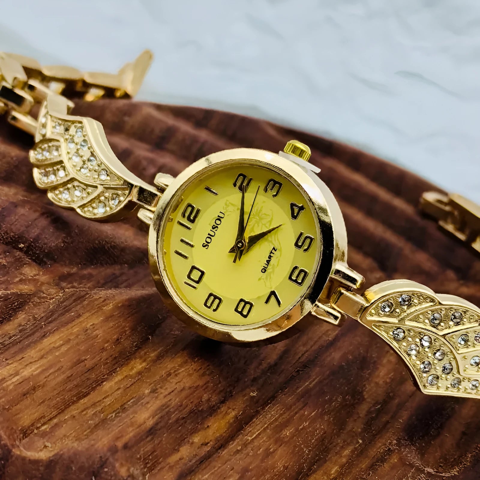 Women's stainless steel watch with round dial showing gold surface colour and vachette clasp