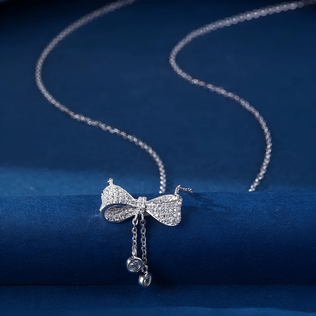 S925 sterling silver necklace with bow pendant on an O-ring chain, shown at clavicle length.