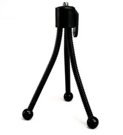 Small black iron mini tripod with ball head, shown extended and collapsed next to a mobile phone.