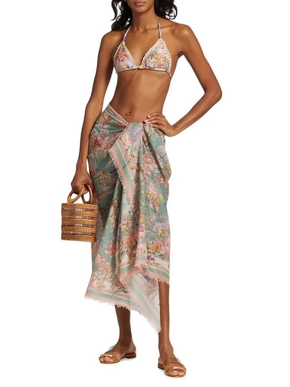 Women's creamy white floral bikini set with top, briefs, and matching skirt on a mannequin.