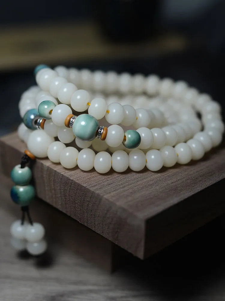 White jade bodhi seed bracelet with 108 flat round beads in two sizes on wrist