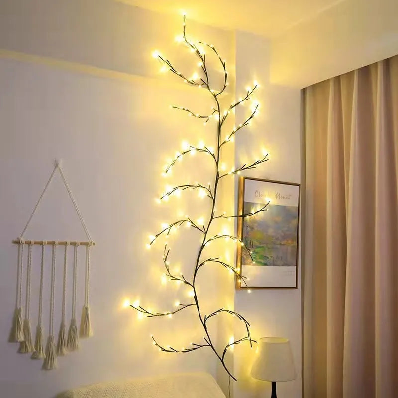 Flexible willow vine Christmas garland with warm white LED lights bent into a decorative shape on a wall.
