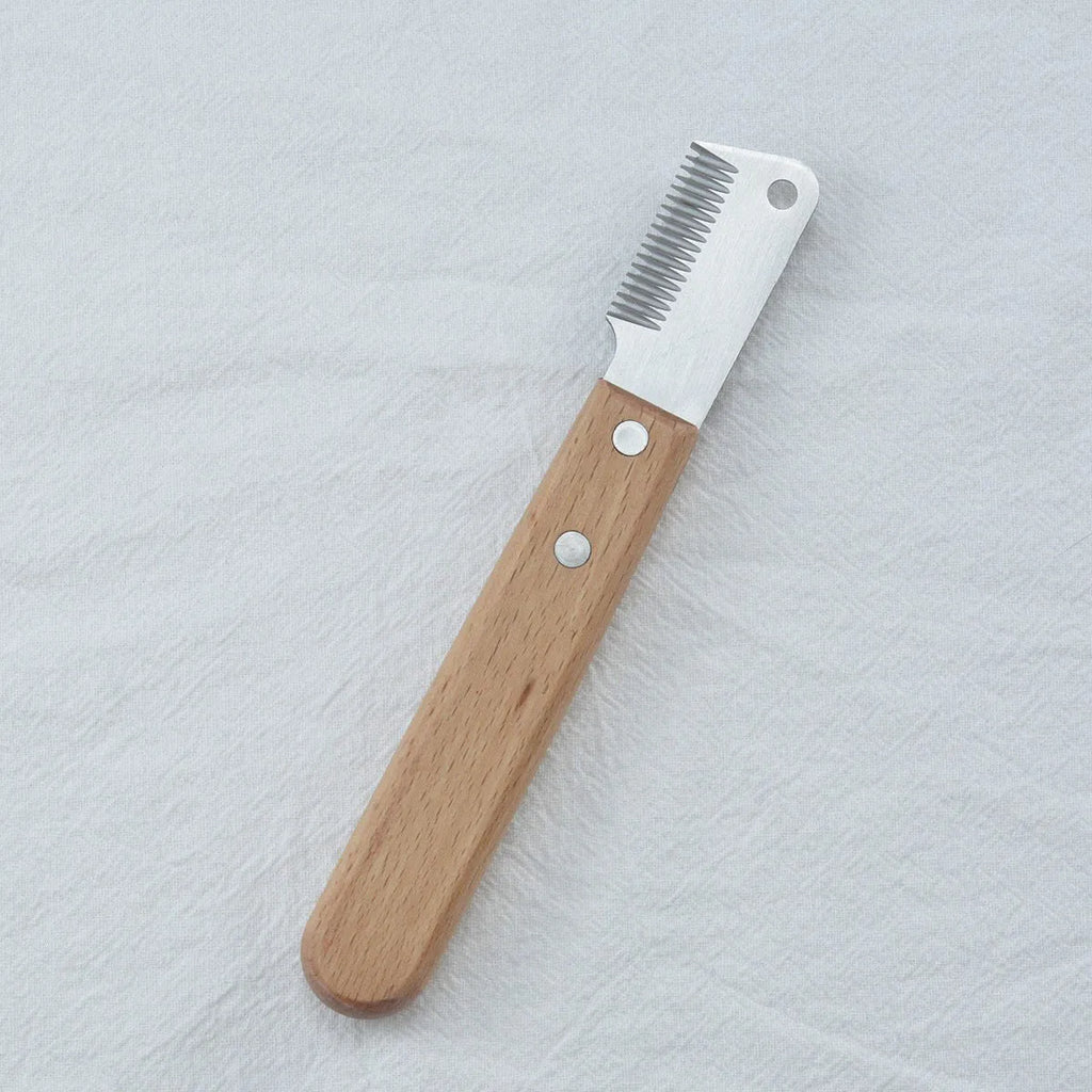 Pet stripping comb grooming tool with a wood handle and metal blade for dogs and cats.