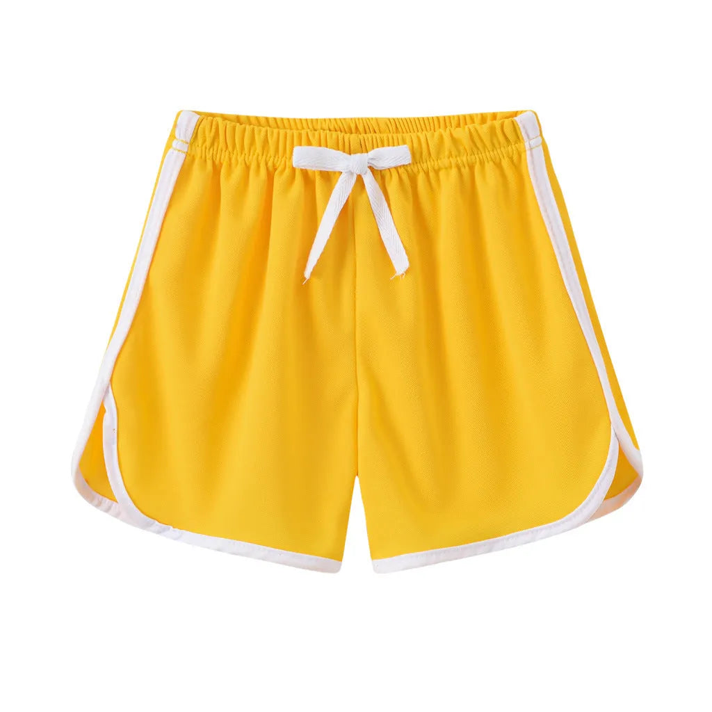 Children's polyester holiday shorts in multiple colours and patterns including stripes, leopard print, and pineapple design.
