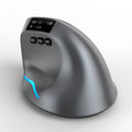 Grey vertical ergonomic Bluetooth mouse with USB charging port on a desk.