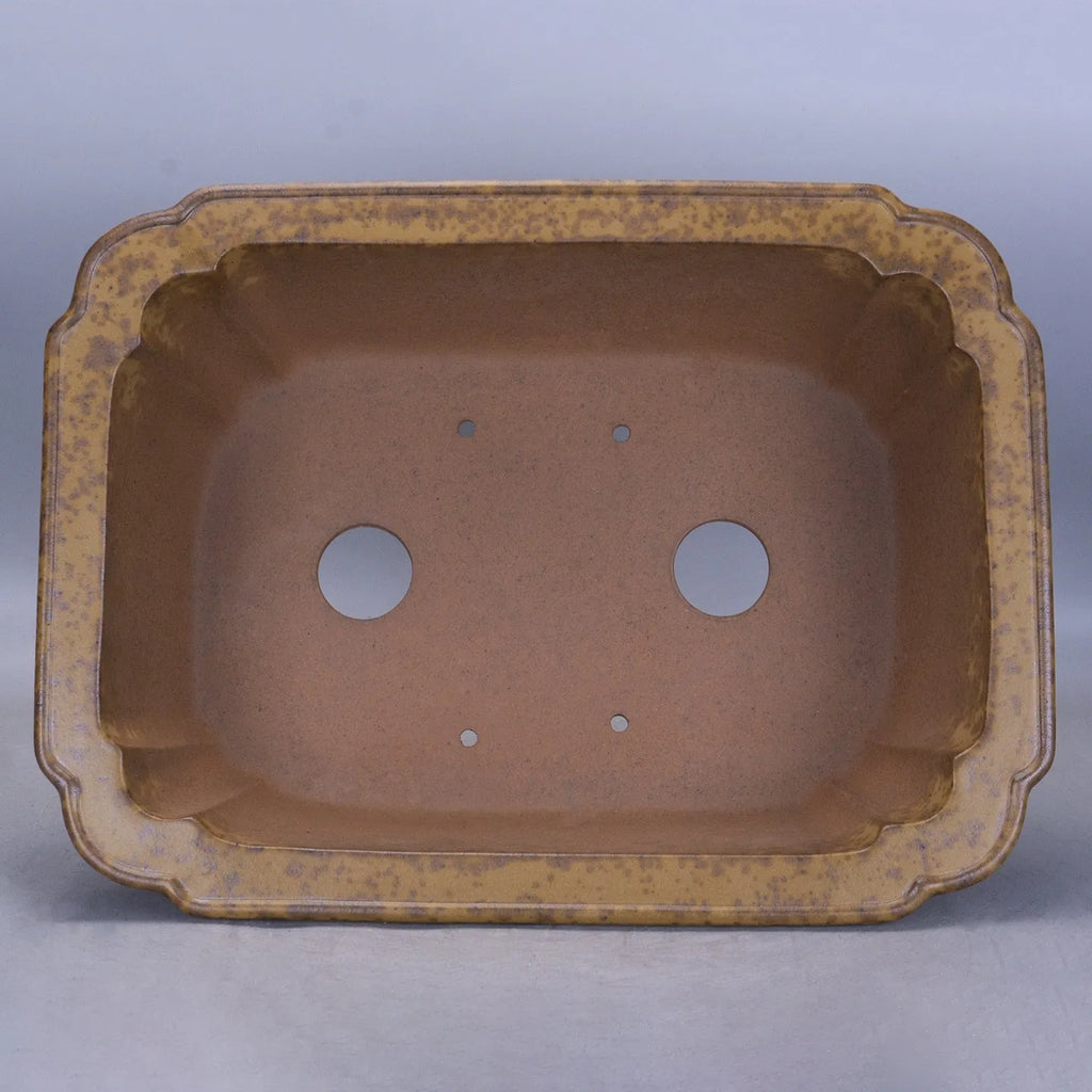A large rectangular purple sand mud flowerpot with angled segment design on a floor.