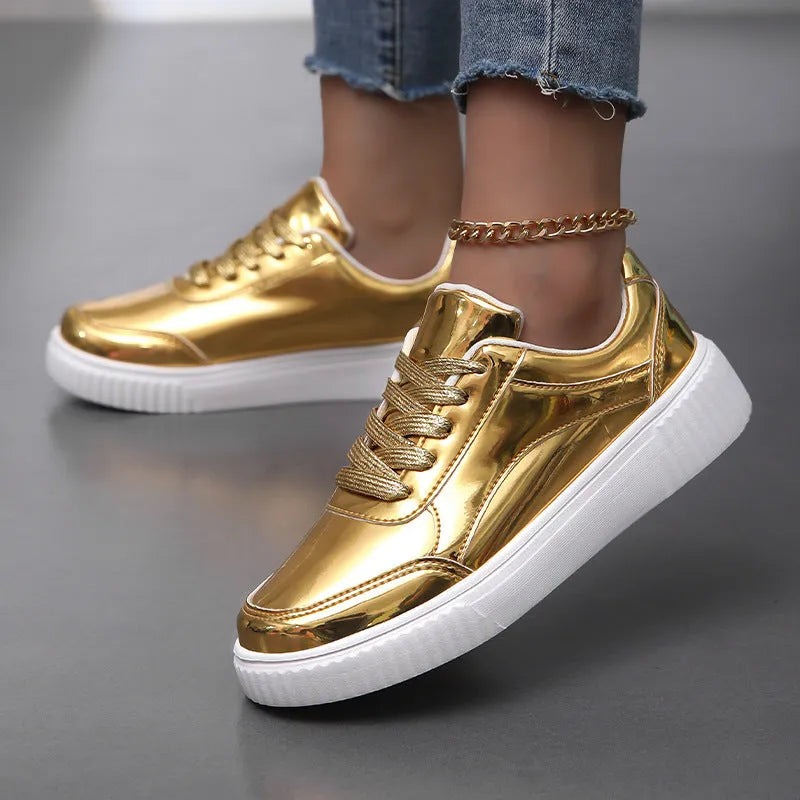 Gold sequinned platform sneakers with round toe and thick MD sole on white background.