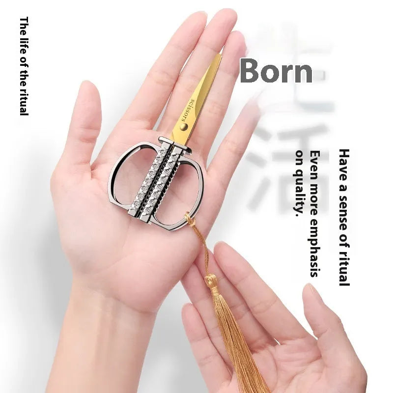 Gold, black, and silver art paper cutting scissors with straight head blades on a white background