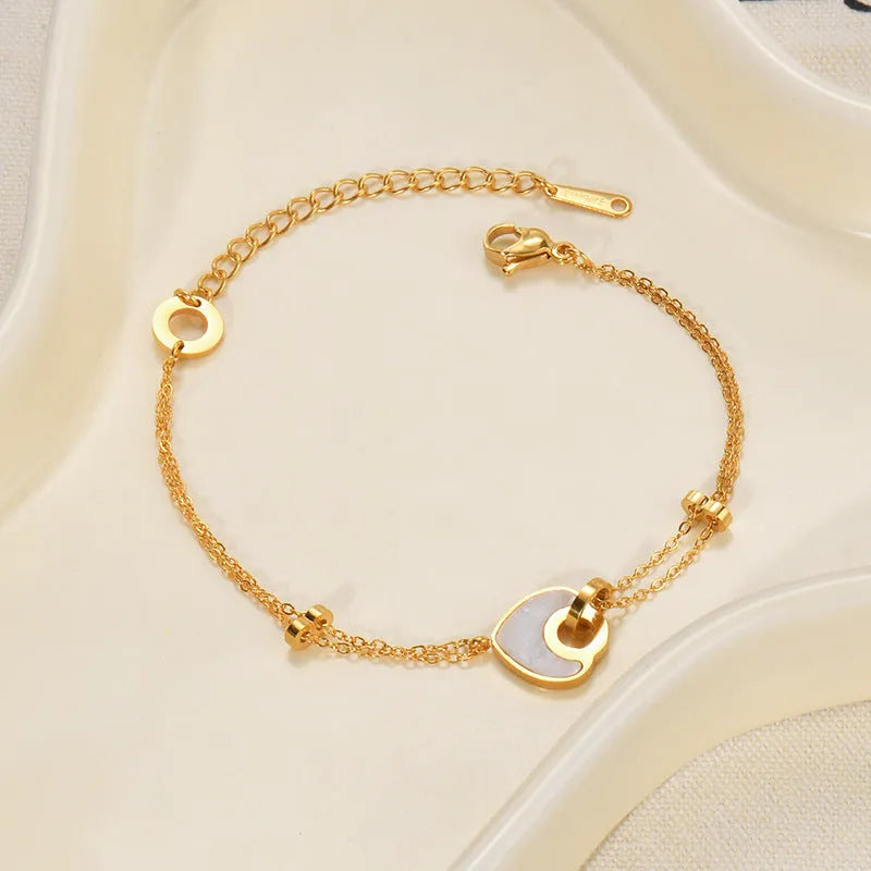 Silver stainless steel bracelet with a double-layer heart pendant featuring dark resin insets