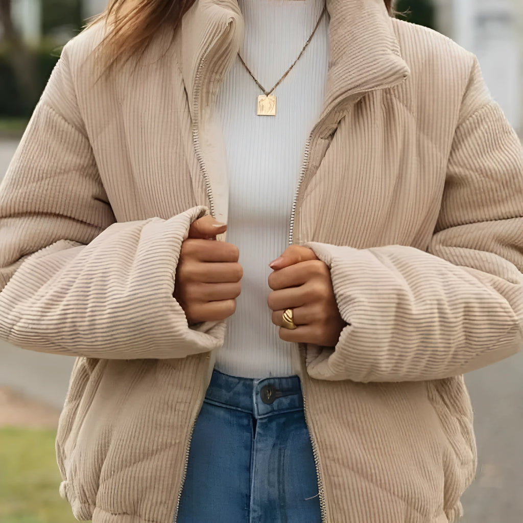 Apricot coloured women's corduroy zip jacket with stand collar and long sleeves on a hanger.