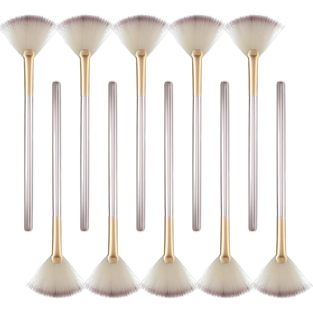 Ten champagne-coloured fan makeup brushes with soft fibre bristles and protective covers laid out.