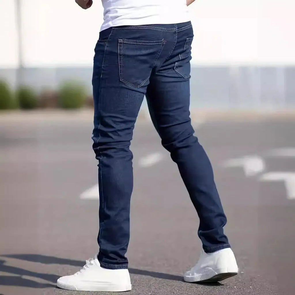 Men's dark blue slim fit cotton jeans showing skinny leg silhouette and street fashion style