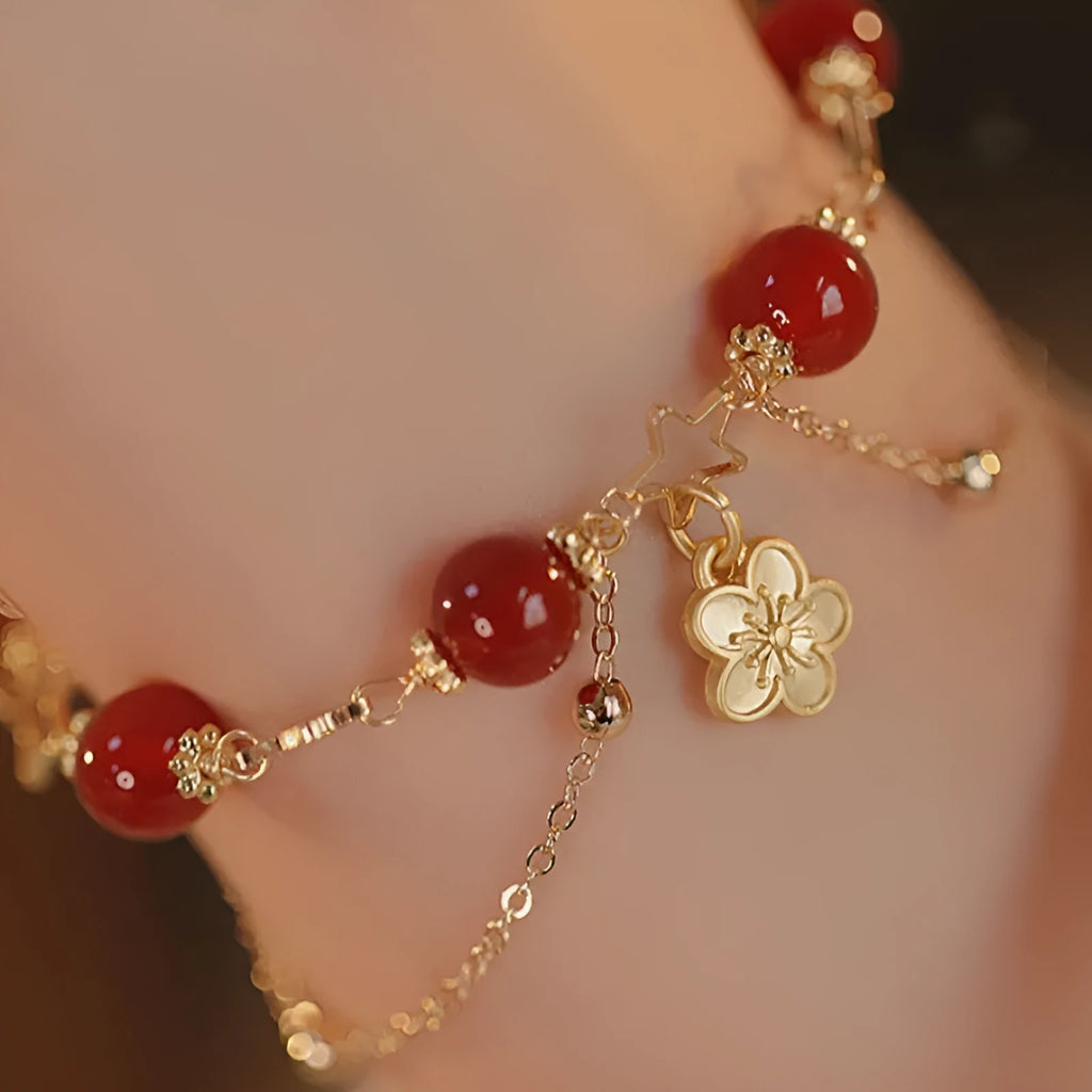 Red agate double layer bracelet with floral and peach blossom design on a wrist