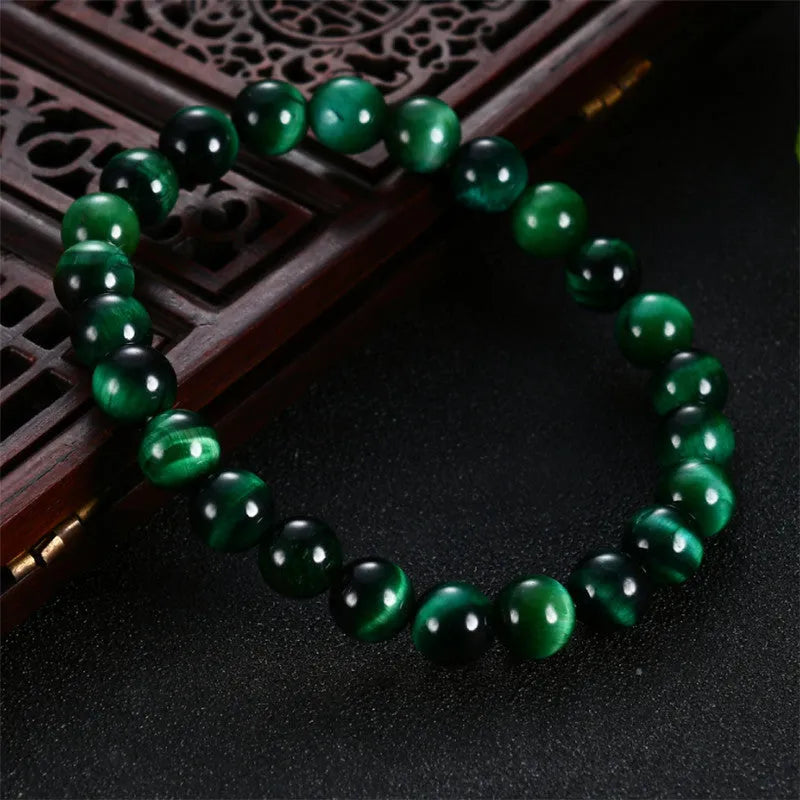 Green Tiger Eye stone bracelet with polished geometry beads on a wrist.