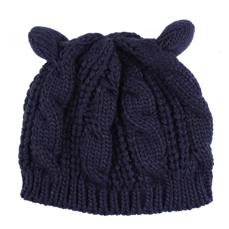 Hand made red knitted beanie hat with 3D cat ears on a white background