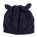 Hand made red knitted beanie hat with 3D cat ears on a white background