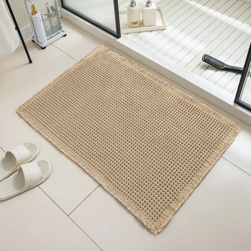 A square, checkered-pattern bathroom carpet in a choice of colours on a tiled floor.