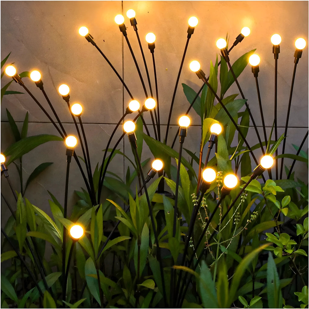 Solar powered LED ground spike garden light with multiple warm white and colour LED heads on stainless steel stake.