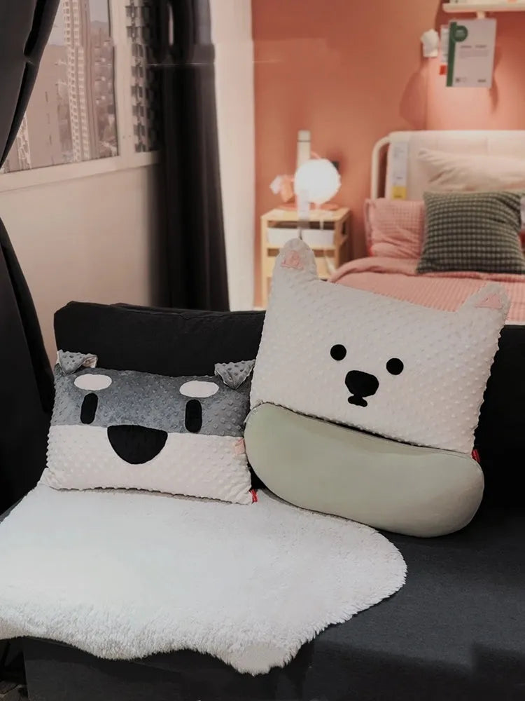 Grey and white West Highland terrier puppy-shaped dog pillow on a sofa.